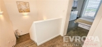 Chodba s modern� dla�bou, vedouc� do sv�tl� lo�nice s velk�mi okny a vestav�n�mi sk��n�mi, zd�raz�uje elegantn� design a funk�nost.