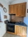 Mal� kuchy� s d�ev�n�mi sk��n�mi, elektrick�m spor�kem a dla�bou. M� praktick� uspo��d�n� a je ide�ln� pro men�� prostory.