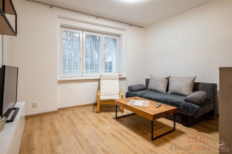 Sv�tl� ob�vac� pokoj s parketovou podlahou, velk�mi okny a modern�m n�bytkem, ide�ln� pro �tuln� bydlen� v rekonstruovan�m byt�.