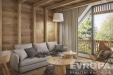 �tuln� ob�vac� pokoj s d�ev�n�mi st�nami, velk�mi okny a modern�m n�bytkem. Sv�tl� podlaha dopl�uje p��rodn� vzhled interi�ru.