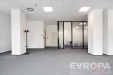 Modern� komer�n� prostor s kobercovou podlahou, prosklenou p���kou a sv�tl�m interi�rem, ide�ln� pro kancel��sk� vyu�it�.