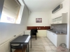 Kuchy�sk� kout s dla�bou a parketovou podlahou, modern� b�l� linka a velk� st�e�n� okno pro dostatek sv�tla