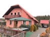 Jednopatrov� rodinn� d�m s �ervenou st�echou, d�ev�n�m balkonem a prostornou p�edzahr�dkou nab�z� klidn� bydlen� v p��rodn�m prost�ed�.