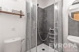 Mal� koupelna s modern�mi sprchov�mi obklady, sklen�n�mi dve�mi a jednoduch�m umyvadlem. Modern� design a elegantn� proveden�.