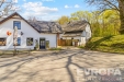 Pr��el� modern�ho rodinn�ho domu s d�ev�nou st�echou, obklopen�ho zahradou a lemovan�ho p��jezdovou cestou na klidn�m okraji lesa.