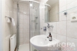 Kompaktn� koupelna s modern�m sprchov�m koutem, dla�bou a b�l�m umyvadlem, nab�z� �ist� a funk�n� design s leskl�mi chromovan�mi armaturami.