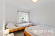 Sv�tl� lo�nice s parketovou podlahou a dv�ma jednol��ky, velk� okno s b�l�mi z�v�sy, modern� minimalistick� styl