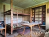 Podkrovn� lo�nice s d�ev�nou patrovou postel�, vestav�n� poli�ky a vintage n�bytek, vy�aduje renovaci.