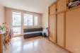 Sv�tl� ob�vac� pokoj s parketovou podlahou, velk� okna s v�hledem do zelen� a vstupem na balkon