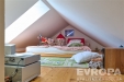 Podkrovn� lo�nice s d�ev�nou podlahou, �ikm�m stropem a st�e�n�m oknem, �tuln� a ide�ln� pro d�tsk� pokoj �i kreativn� �to�i�t�.
