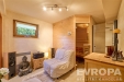 Relaxa�n� pokoj s d�ev�nou saunou, parketovou podlahou, modern�m za��zen�m a velk�mi okny, nab�z� klidn� a �tuln� prostor pro odpo�inek.