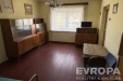 Ob�vac� pokoj s d�ev�nou podlahou, velk�m oknem a retro n�bytkem, sv�tl� interi�r s v�hledem do klidn�ho okol�, zachoval� stav.