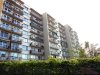 Vy��� bytov� d�m s balkony, modern� fas�dou a velk�mi okny, ide�ln� pro m�stsk� bydlen�, pobl�� zelen� a park�.
