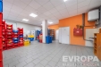 Pracovn� prostor s dla�bou, �lo�n�mi reg�ly a vymalovan�mi zdmi, vhodn� pro skladovac� nebo komer�n� vyu�it�.