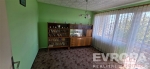 Pr�zdn� m�stnost s velk�mi okny, retro kobercem a vestav�n�mi sk��n�mi, zelen� st�ny, p��rodn� sv�tlo, ide�ln� pro renovaci.