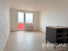 Sv�tl� ob�vac� pokoj s velk�mi okny, lamin�tov� podlaha, modern� interi�r s b�l�mi st�nami a radi�torem, p�ipraven k nast�hov�n�.