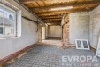 Rozestav�n� m�stnost s betonovou podlahou a odkryt�mi cihlami, vhodn� pro rekonstrukci, nab�z� potenci�l pro modern� p�estavbu.