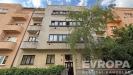 Fas�da bytov�ho domu s velk�mi okny a rekonstruovanou om�tkou, nach�z� se na klidn� ulici.