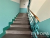 Schodi�t� v bytov�m dom� s kovov�m z�bradl�m a betonov�mi schody, dob�e udr�ovan� prostory, sv�tl� st�ny v modern�m stylu.