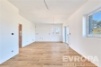 Sv�tl� ob�vac� pokoj s parketovou podlahou, velk�mi okny a modern�m stylem, ide�ln� pro rodinn� bydlen�.