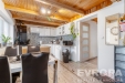 Modern� kuchy� s dla�bou, d�ev�n�m stropem a vestav�n�mi spot�ebi�i, sv�tl� j�delna s velk�mi okny a elegantn�mi �ern�mi �idlemi.