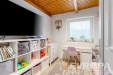 D�tsk� pokoj s d�ev�n�m stropem, sv�tl�mi st�nami a vestav�n�m �lo�n�m prostorem, modern� dekorace a velk� okno pro p�irozen� sv�tlo.