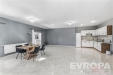 Prostorn� kuchy� s modern�mi prvky, dla�bou a vestav�n�mi sk��n�mi spojuje elegance a funk�nost, ide�ln� pro rodinn� va�en�.