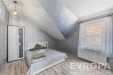 Podkrovn� lo�nice, modern� styl, d�ev�n� podlaha, velk� okna s krajkov�mi z�v�sy, sv�tl� a prostorn� atmosf�ra.