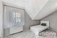Podkrovn� lo�nice s lamin�tovou podlahou a velk�m st�e�n�m oknem, modern� proveden� v b�l� barv�, minimalistick� design