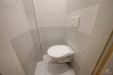 Mal� koupelna s modern�mi obklady, sv�tl� dla�by a �ist� design, ide�ln� pro efektivn� vyu�it� prostoru v rekonstruovan�m byt�.
