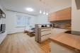 Modern� kuchy� s d�ev�nou pracovn� deskou, parketov� podlaha, propojena s ob�vac�m pokojem, sv�tl� prostor d�ky velk�m okn�m.