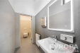 Modern� koupelna s dla�bou, velk�m zrcadlem a sv�tl�m umyvadlem, kter� dopl�uje modern� styl a kvalitn� materi�ly.