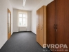 Pr�zdn� kancel��sk� m�stnost s tmav�m kobercem, vestav�n�mi sk��n�mi a velk�m oknem. Sv�tl� st�ny a dobr� p�irozen� osv�tlen�.