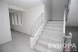 Vstupn� hala s b�l�mi st�nami, sv�tlou dla�bou a modern�m schodi�t�m. Vynikaj� velk� okna a minimalistick� styl interi�ru.