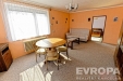 Sv�tl� ob�vac� pokoj s velk�m oknem, kobercem a d�ev�n�m n�bytkem. Tradi�n� styl, p��jemn� atmosf�ra vhodn� pro rodinn� sezen�.