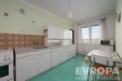 Sv�tl� kuchy� s parketovou podlahou, modern�mi b�l�mi sk���kami a velk�mi okny nab�zej�c�mi kr�sn� v�hled.