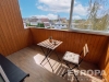 Zasklen� balkon s d�ev�n�m oblo�en�m nab�z� �tuln� prostor pro relaxaci, v�hled na klidnou reziden�n� �tvr� a kvalitn� d�ev�nou podlahu.